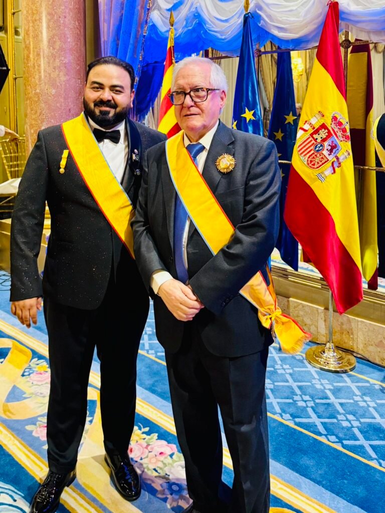 Dr. Waqas Nadeem receiving the Crown of Excellence and Crown of Humanity Awards during a humanitarian ceremony in Barcelona, recognizing his leadership in refugee welfare and social development.