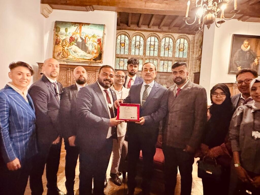 Field Marshal Syed Alam Mehmood receives a commemorative shield from Dr. Waqas Nadeem, Chairman of Human Trust International, during an official humanitarian meeting in Italy, joined by delegation members and community leaders.